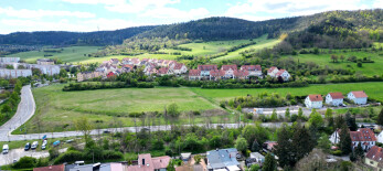 Luftaufnahme des Baugebietes zu sehen sind viele Häuser und im Vordergurnd eine freie Baufläche
